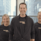 Three people in black shirts that say "Broadway Media" facing forward and smiling.